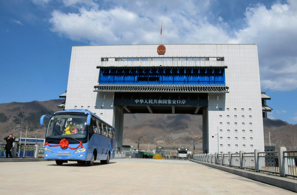 This photo taken on April 8, 2019 shows a tour bus driving past the border between China and North Korea as it makes its way to North Korea, in Ji an in China northeastern Jilin province. (Photo by STR / AFP) 
