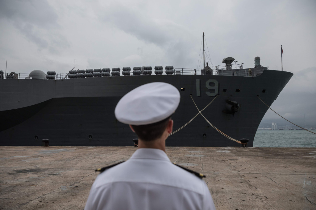 A crew member stands before the USS Blue Ridge during a port call in Hong Kong on April 20, 2019. (Photo by DALE DE LA REY / AFP)