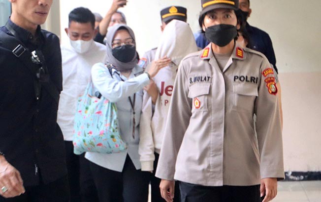 AG (face closed) after undergoing a trial at the South Jakarta District Court. Photo: MI