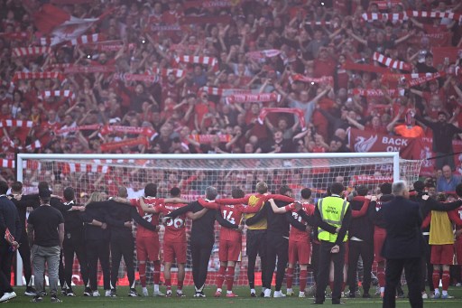 Liverpool celebrate with their fans on the pitch after the English Premier League football match between Liverpool and Tottenham Hotspur at Anfield in Liverpool, England on April 27, 2025. Paul ELLIS/AFP