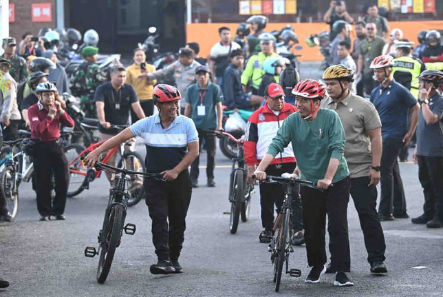 佐科威在马塔兰骑自行车并分发基本必需品